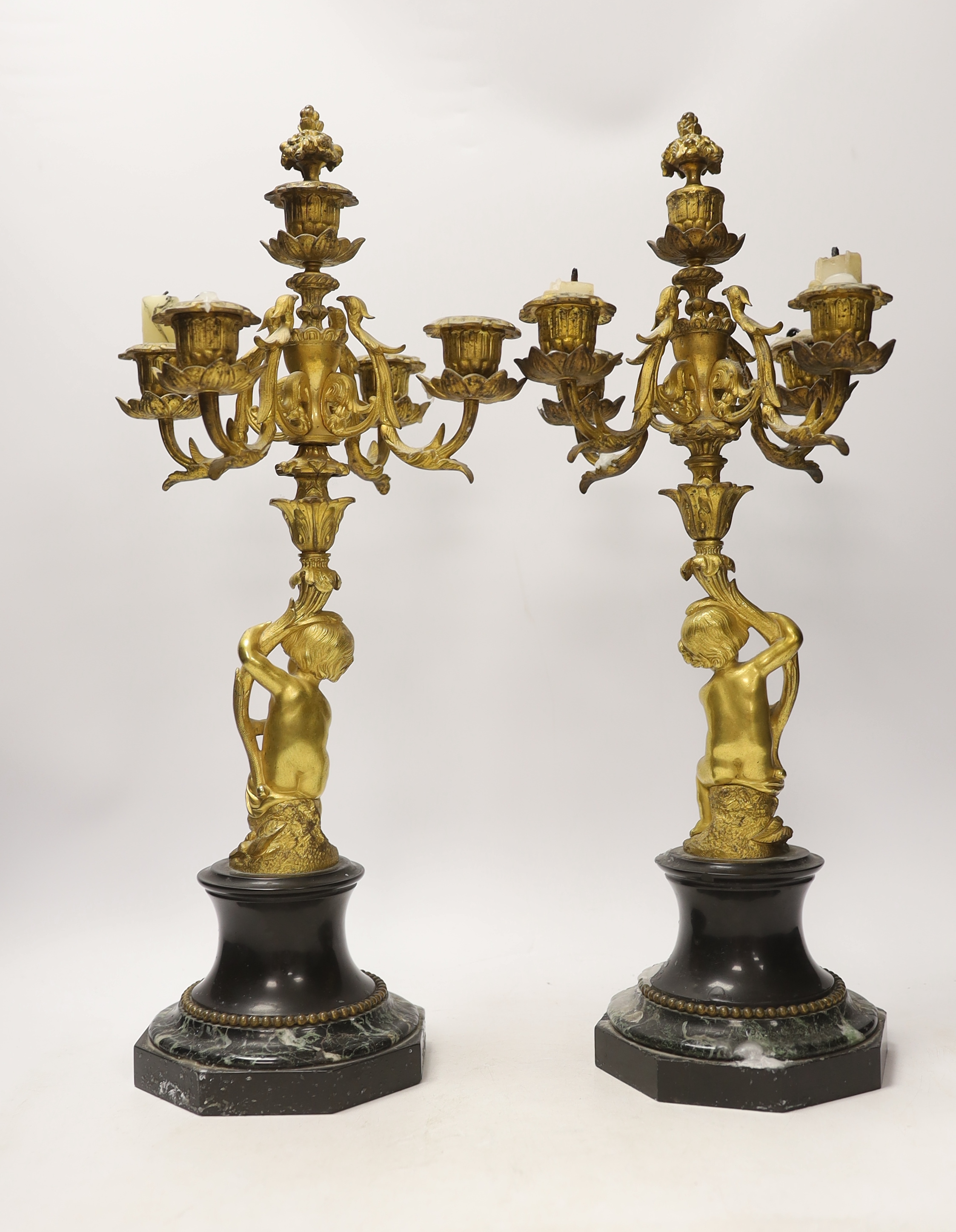 A pair of late 19th century French ormolu cherubic four branch candelabra on marble bases, 47cm